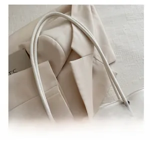 Close-up of slender dual shoulder straps and reinforced metal eyelets on white tote bag