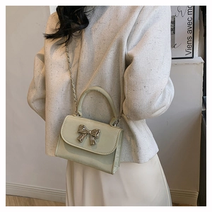 Détail d'un mini sac à main vert menthe avec nœud métallique argenté et chaîne
