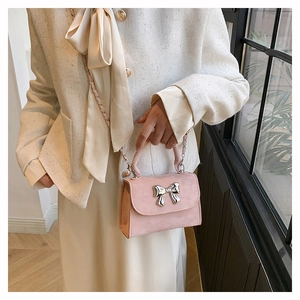Détail d'un mini sac à rabat vieux rose avec boucle nœud métal et bandoulière chaîne