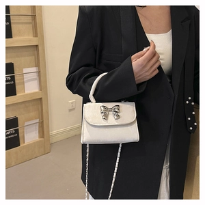 Détail du mini sac à main crème avec nœud métallique argenté et bandoulière chaîne