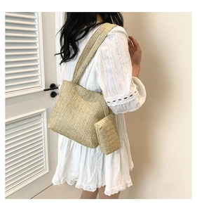 Detail of woven straw tote bag set with wide shoulder strap and matching small pouch