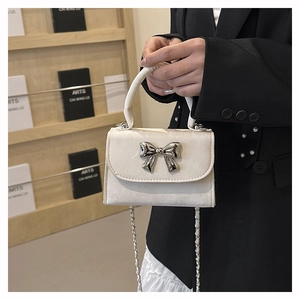 Détail du mini sac à main blanc crème avec boucle noeud argenté et bandoulière