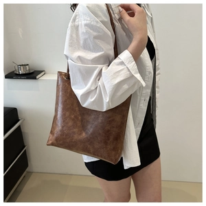 Detail view of large brown vintage tote bag in soft leather-like material for daily wear