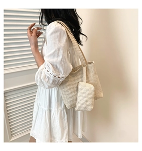 Close-up of beige woven straw tote bag featuring herringbone texture and matching pouch