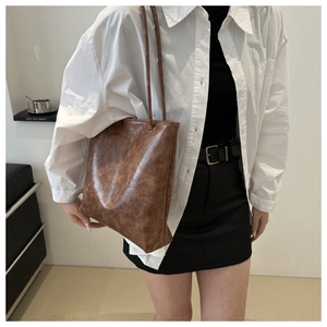 Detail shot of the vintage brown faux leather texture and reinforced metal eyelets of the tote