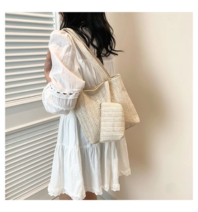 Detail of woven straw tote bag and matching pouch with textured herringbone pattern