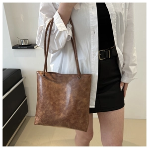 Close-up of vintage brown tote bag with retro textured faux leather and slim straps