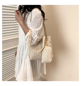 Detail of cream straw woven tote bag featuring delicate wavy texture and matching pouch