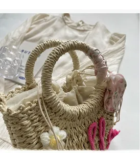 Detail of bohemian straw bag featuring 3D floral accents and floral silk scarf handle
