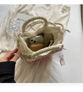Interior view showing spacious storage capacity of woven straw tote bag with floral accents