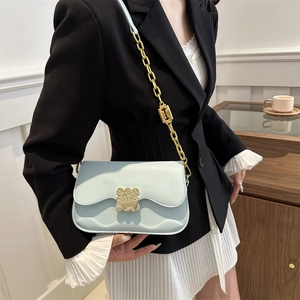 Chic light blue crossbody saddle bag with golden bear clasp and chain strap for women