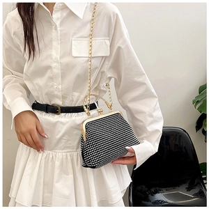 Detail of black evening clutch bag with white pearl beading and gold chain handle
