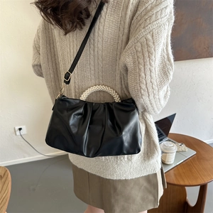 Chic black pleated cloud bag with elegant pearl handle and adjustable shoulder strap