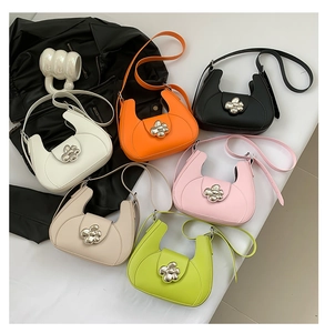 Vue à plat de six sacs hobo colorés avec boucle florale en métal sur fond blanc épuré