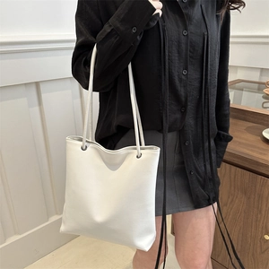 Minimalist white leather tote bag for women with dual shoulder straps shown on a model