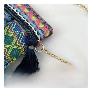 Detail of colorful ethnic embroidery with blue tassel and gold metal hardware on bag
