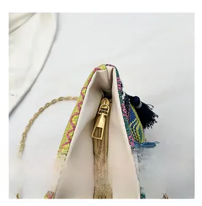 Close-up of the smooth gold metal zipper and colorful woven fabric on ethnic bag