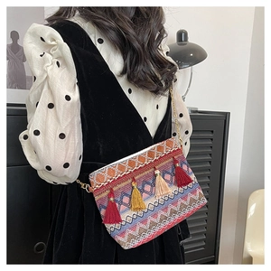 Close-up of bohemian woven crossbody bag featuring colorful geometric patterns and tassels