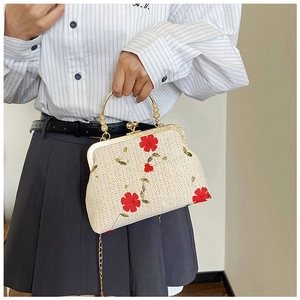 Détail de la broderie florale sur sac tissé crème avec fermoir en métal doré