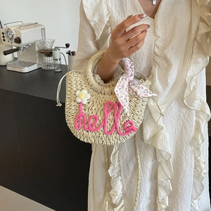 Handwoven straw beach bag with pink hello embroidery and floral scarf detail for women