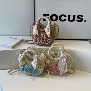 Handmade straw bucket bag with hello embroidery and floral scarf on white background