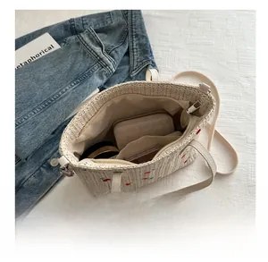 Interior view of straw tote bag with cherry embroidery showing large storage capacity