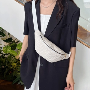 Sac de poitrine tressé blanc avec bandoulière réglable porté par un mannequin en style