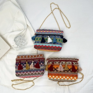 Three bohemian woven crossbody bags with tassels and colorful geometric patterns
