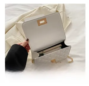 Detailed interior capacity view of white quilted crossbody bag with phone and wallet