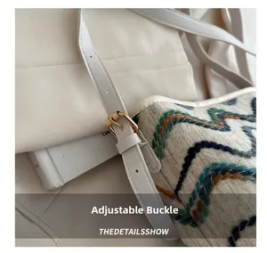 Detailed view of adjustable faux leather shoulder strap with gold buckle on plaid bucket bag