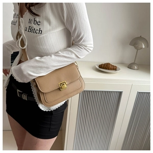 Close-up of light brown PU leather crossbody bag with elegant gold square metal buckle