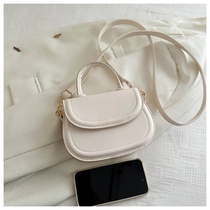 Mini cream PU saddle bag detail showing compact size with smartphone for scale