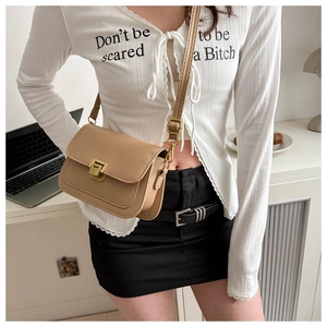 Model wearing a camel square shoulder bag with gold metal buckle in office setting