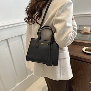 Chic black PU leather square tote bag with gold lettering shown in a stylish cafe setting