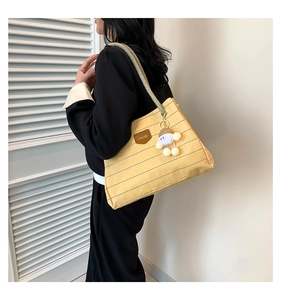 Detail of yellow plaid canvas tote bag with woven rope handle and plush cloud charm