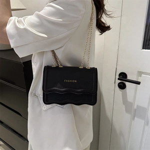 Petit sac noir minimaliste avec bandoulière chaîne dorée et rabat à volants moderne