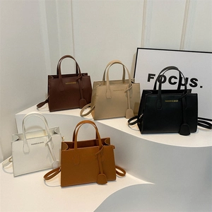 Minimalist leather tote bag collection in five colors on geometric display stands