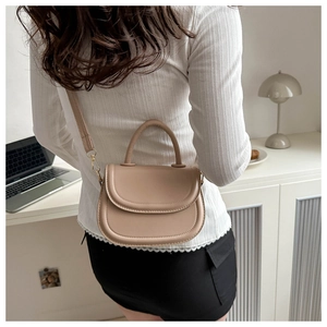 Detail of light beige saddle crossbody bag with fine stitching and smooth PU leather finish