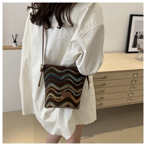 Detail of bohemian bucket bag with colorful wavy weaving and leather fashion patch