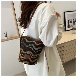 Detail of colorful wave pattern knit fabric and leather patch on retro bucket bag