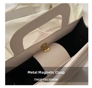 Detail of light beige crossbody bag with premium gold magnetic hardware closure