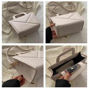 Detailed view of cream geometric patterned crossbody bag with adjustable strap and handles