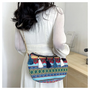 Close-up of bohemian woven shoulder bag with colorful stripes and dangling fringe tassels