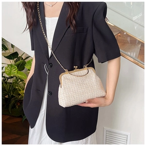 Detail of beige straw weave shell bag showing vintage gold metal clasp and chain strap