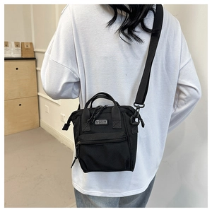 Détail de la bandoulière réglable et des doubles poignées du sac en toile noire polyvalent