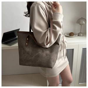 Detail of vintage textured tote bag with leather straps and rivets in office setting