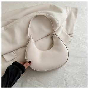 Detailed view of a cream white hobo crescent bag with smooth matte leather finish