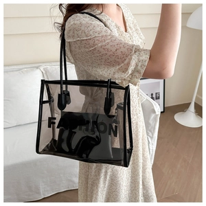 Detailed close-up of transparent tote bag with black leather trim and interior pouch