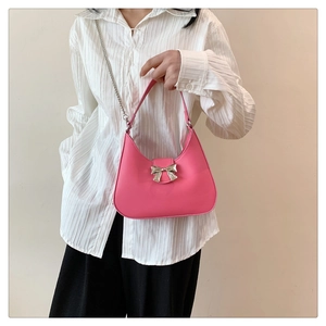 Détail du sac hobo rose avec boucle nœud argentée et bandoulière en chaîne élégante