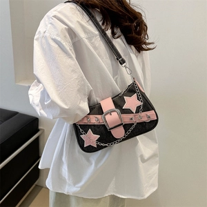 Y2K denim underarm bag with pink stars and metal chain shown on a model's shoulder